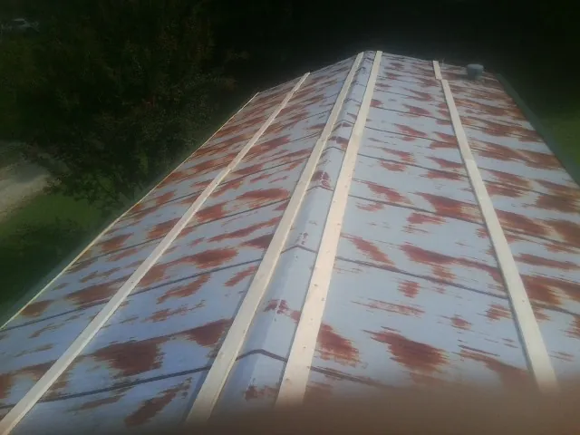 Rusted metal roof panels with new wood purlins before replacement — Storm Damage Roof Repair in Three Lakes by Roofing Brothers