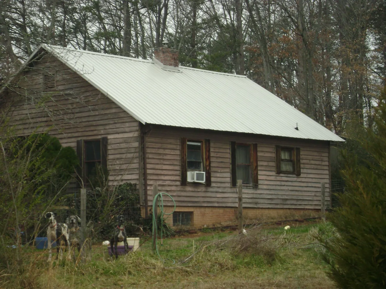 White metal roof on an old wood sided farmhouse, from a Metal Roof Installation job in Three Lakes